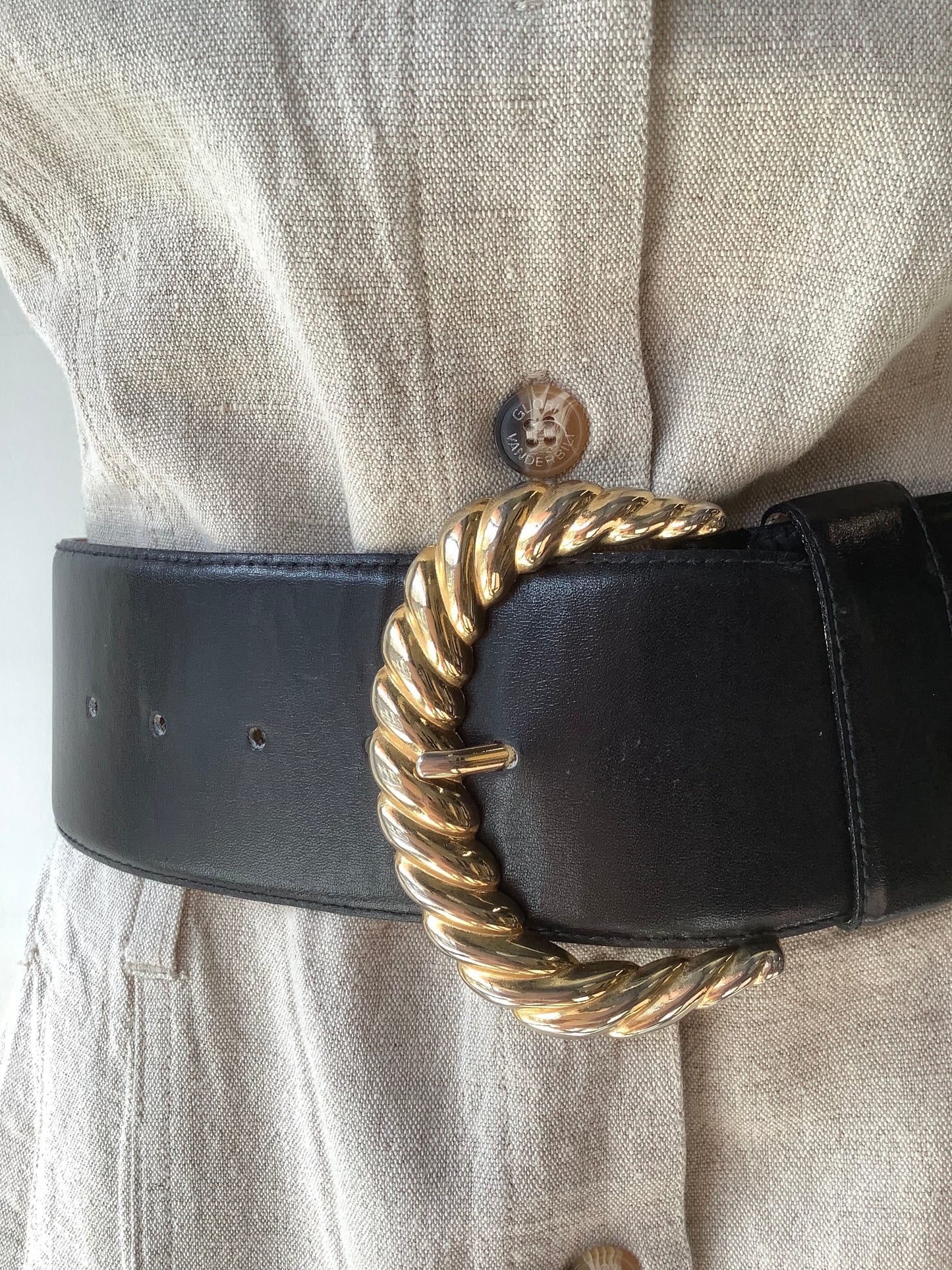 Wide black leather belt with big gold buckle