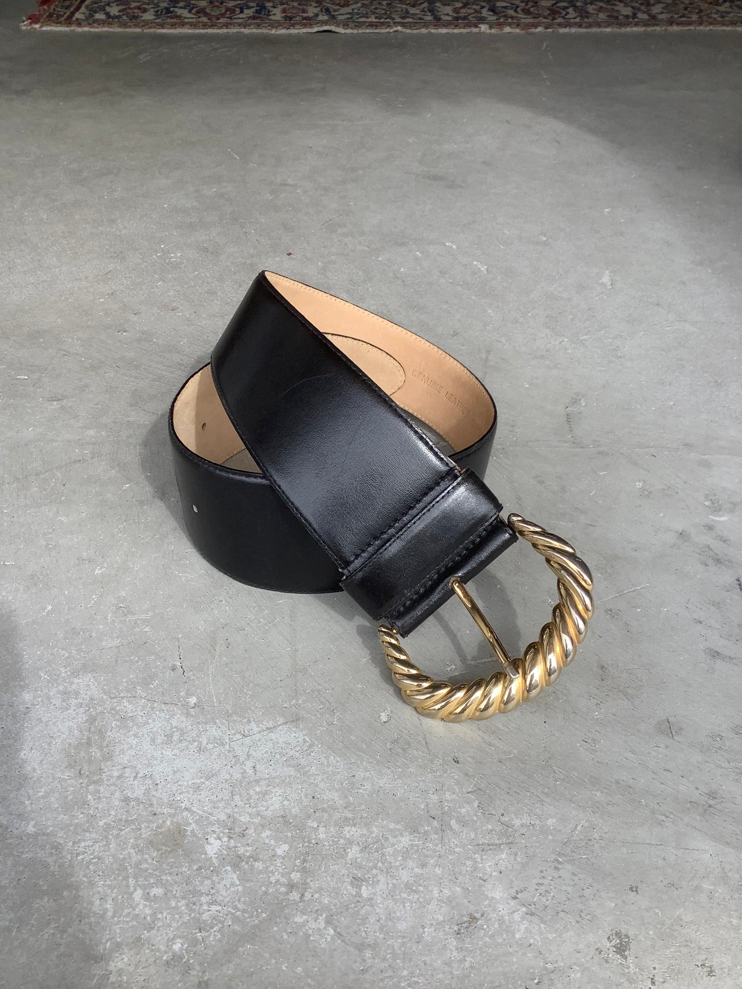 Wide black leather belt with big gold buckle